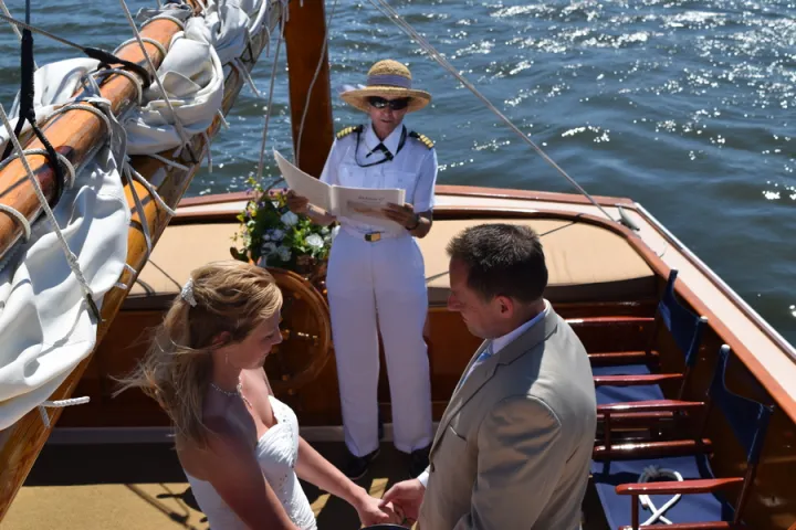 Sail Selina offers more than just an exquisite nautical-themed wedding venue it provides an opportunity to connect with your partner and nature in a unique and unforgettable way - This lovely image captures the intimate and playful moments between newlyweds on their boat wedding day, surrounded by the stunning vistas of St. Michaels, MD - Book your Sail Selina adventure today and experience the magic for yourself.