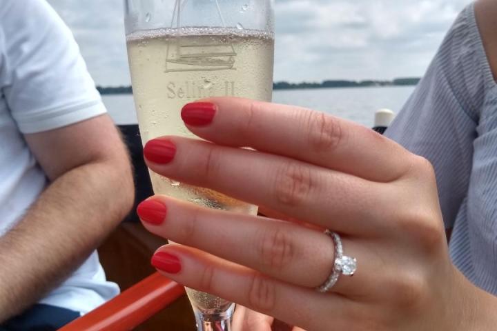 Toast to your love story with Sail Selina, the perfect nautical wedding or boat elopement venue in St. Michaels, MD - This emotional image captures the pure joy and happiness of a newly engaged couple aboard Sail Selina, with a breathtaking view of the Miles River - Book your Sail Selina adventure now and celebrate your love in style
