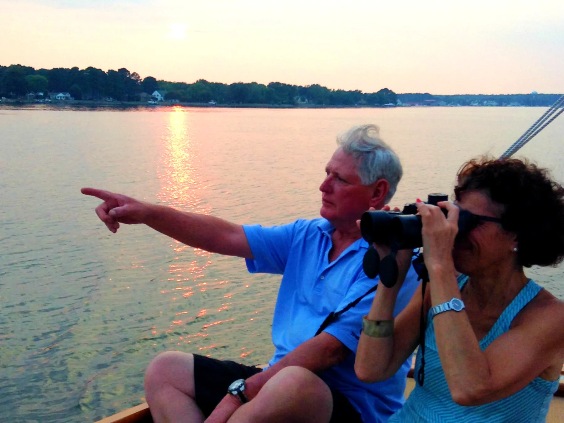 Sail Selina offers the ultimate romantic experience with sunset cruises on the Chesapeake Bay in St. Michaels, MD - This stunning image showcases a couple sharing the beauty and tranquility of the sunset, basking in the glow of the moment - With the gentle lull of the waves and the fresh salty scent of the sea, Sail Selina's sunset cruise promises to be a cherished and unforgettable experience - Book now and immerse yourself in the awe-inspiring beauty of the open water!